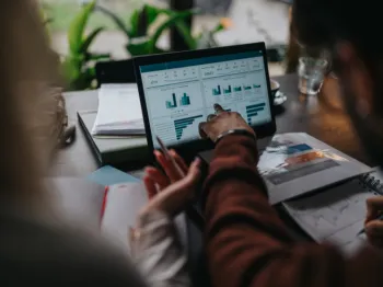 Business professionals reviewing local business performance data on a laptop