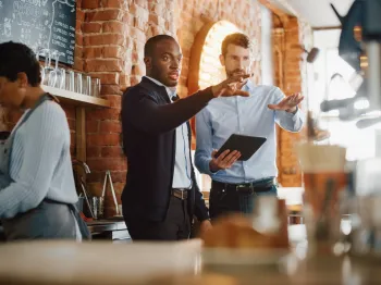 Restaurant professionals reviewing operations together inside a local food business