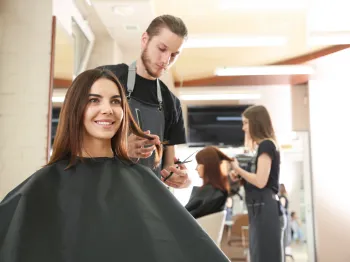 Professional hair salon stylist providing a service to a client