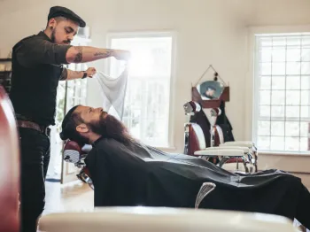 Professional barber providing grooming services to a client in a local barbershop