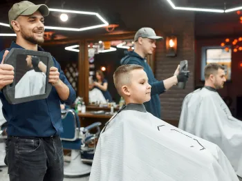 Barber showing a client his finished haircut in a professional barber shop