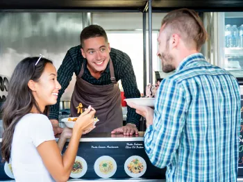 Food truck owner serving meals to local customers