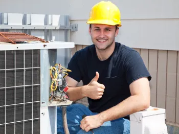 HVAC technician inspecting and repairing an outdoor air conditioning unit