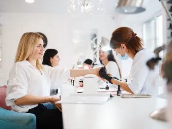 Nail technician performing a manicure for a client in a modern salon