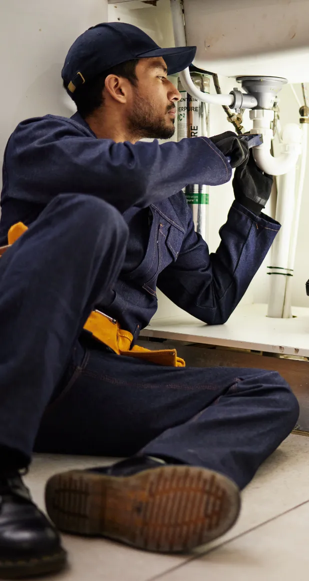 Professional plumber repairing a kitchen sink